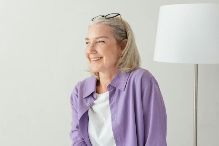 An Elderly Woman in Purple Long Sleeves Smiling