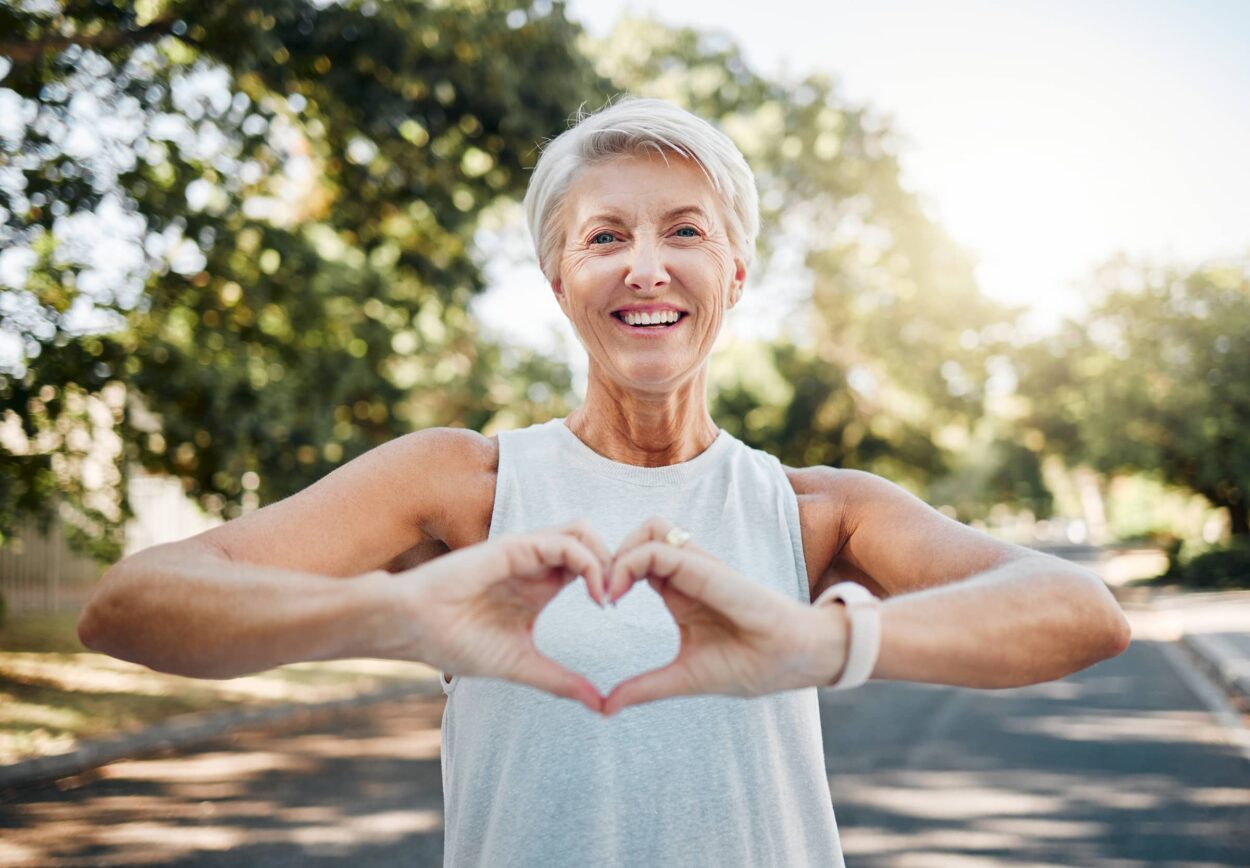 Senior woman after a workout making a heart with her hands